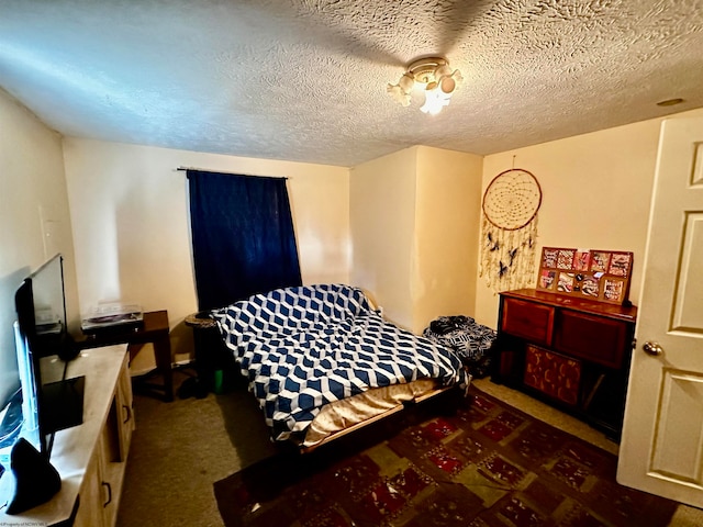 bedroom featuring a textured ceiling and dark carpet