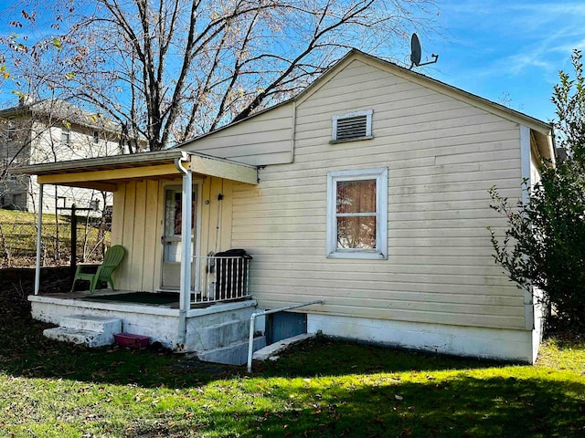 rear view of property featuring a yard