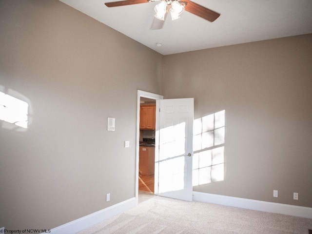 spare room with light colored carpet and ceiling fan