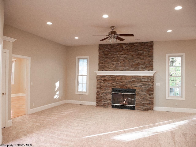 unfurnished living room with a fireplace, carpet, and ceiling fan