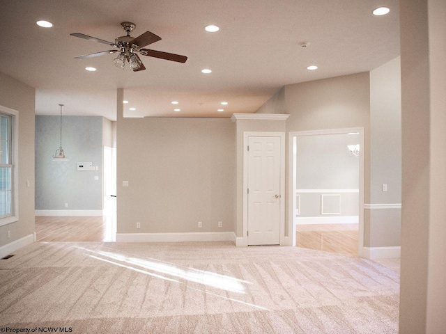 carpeted spare room featuring ceiling fan