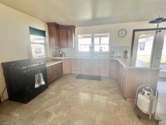 kitchen with kitchen peninsula, a healthy amount of sunlight, and sink