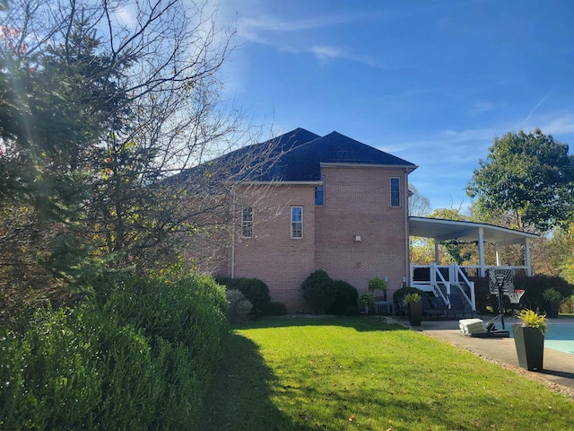 view of side of home featuring a patio and a lawn