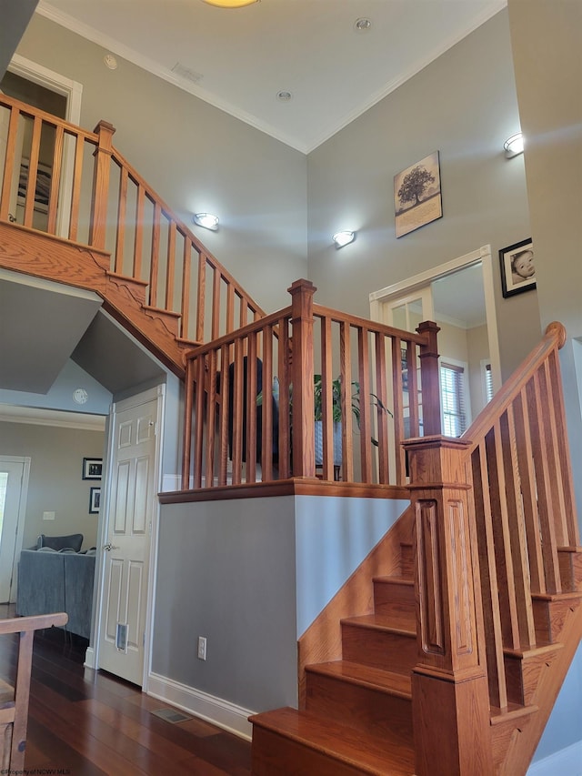 staircase featuring crown molding and hardwood / wood-style floors