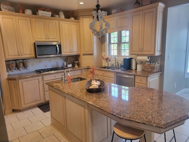 kitchen with sink, a breakfast bar, a kitchen island with sink, and stainless steel appliances