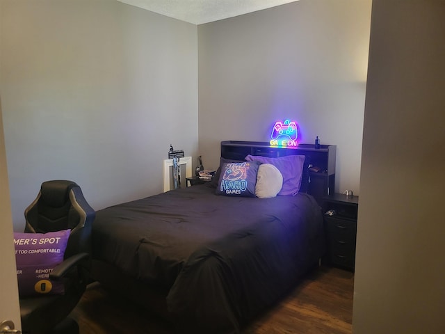 bedroom with a textured ceiling and dark hardwood / wood-style flooring