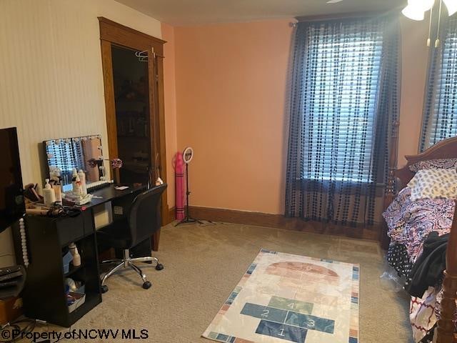 carpeted home office with ceiling fan