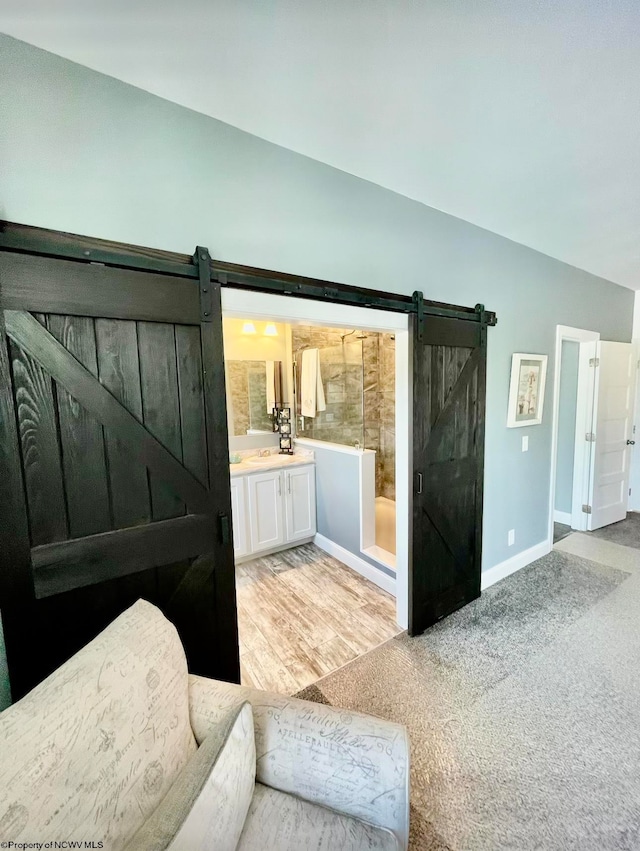 interior space with vanity, hardwood / wood-style floors, a shower, and vaulted ceiling