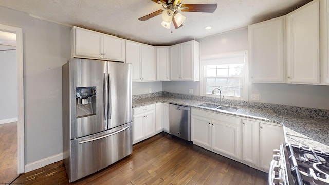 kitchen with dark hardwood / wood-style floors, sink, white cabinetry, appliances with stainless steel finishes, and light stone counters