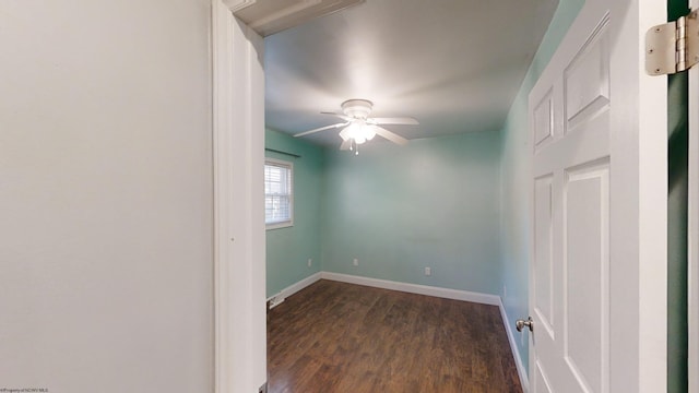 spare room featuring dark wood-type flooring and ceiling fan