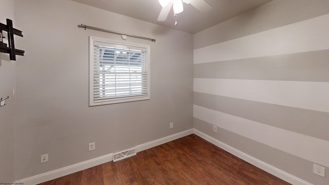 spare room featuring dark wood-type flooring and ceiling fan