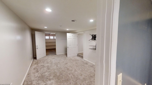 walk in closet with light carpet