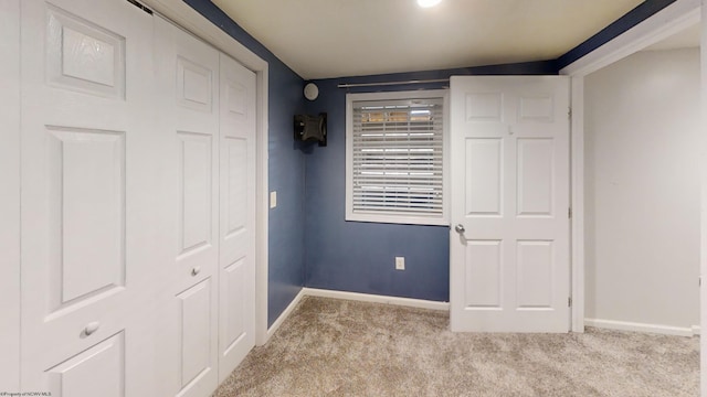 unfurnished bedroom with a closet and light carpet