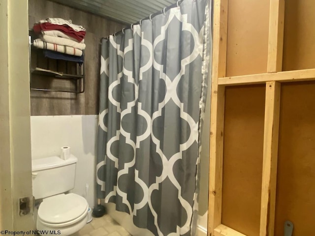 bathroom featuring toilet and a shower with curtain