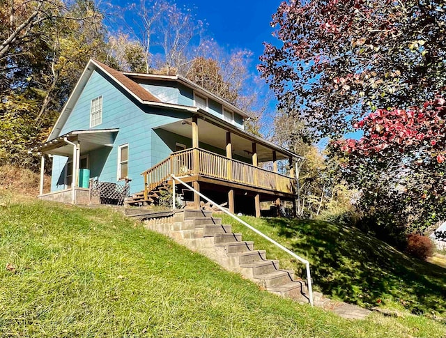 rear view of property featuring a yard and covered porch