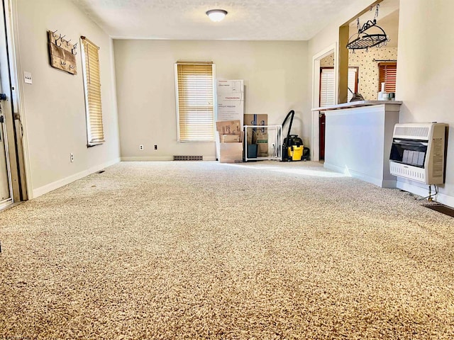 unfurnished living room featuring a textured ceiling, heating unit, and carpet floors