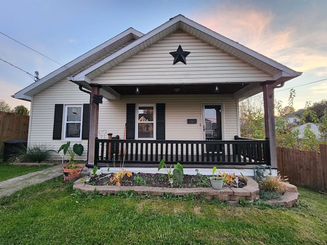 bungalow-style home with a lawn and a porch