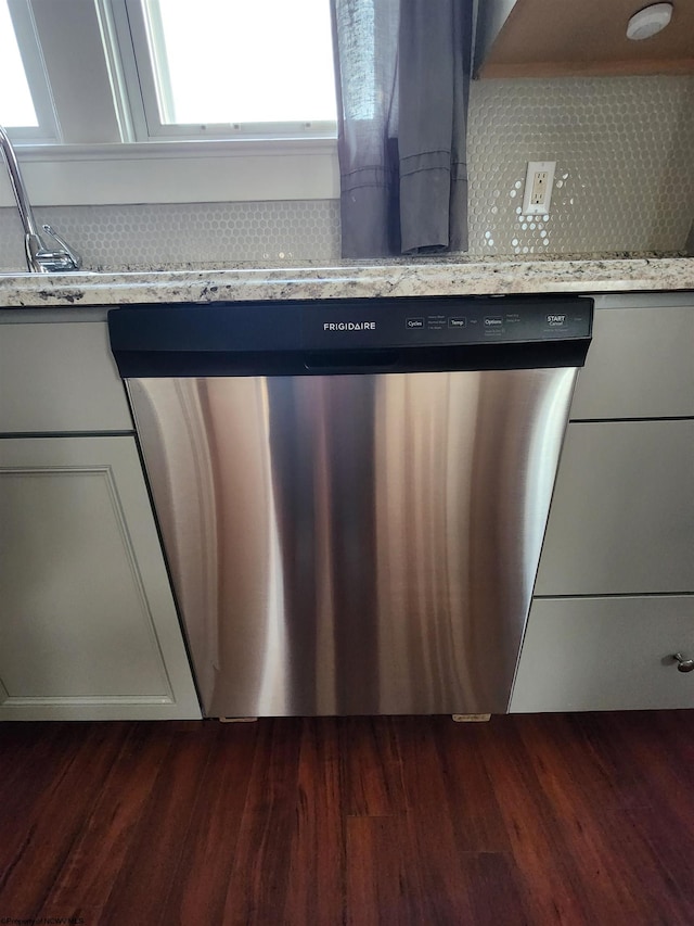 details with stainless steel dishwasher, light stone countertops, and dark hardwood / wood-style floors