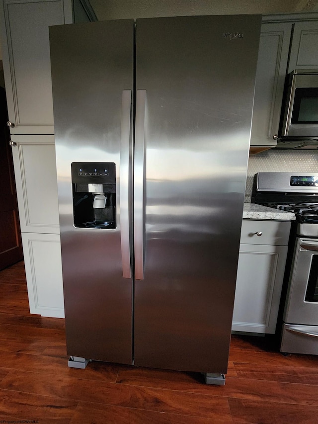 kitchen featuring dark wood-type flooring, backsplash, and appliances with stainless steel finishes