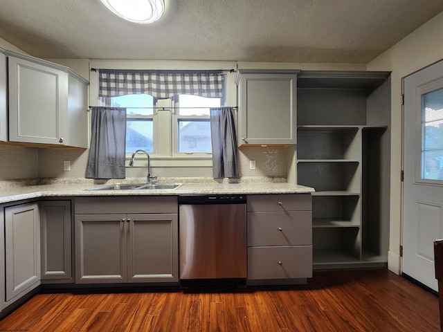 kitchen with stainless steel dishwasher, sink, gray cabinets, and dark hardwood / wood-style flooring