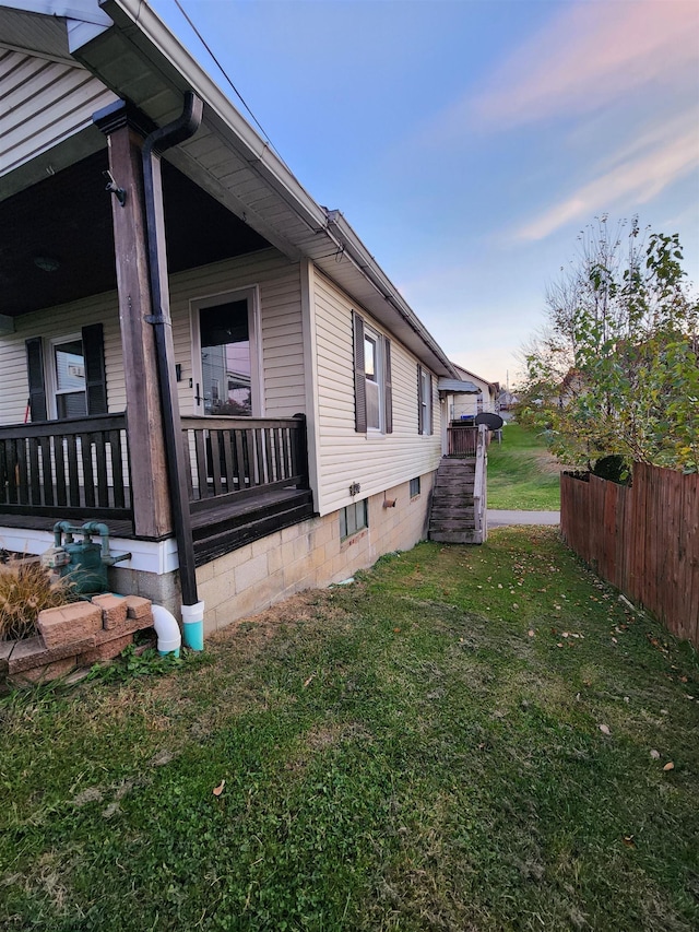 property exterior at dusk featuring a lawn