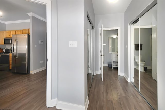 hallway with dark wood-type flooring and ornamental molding