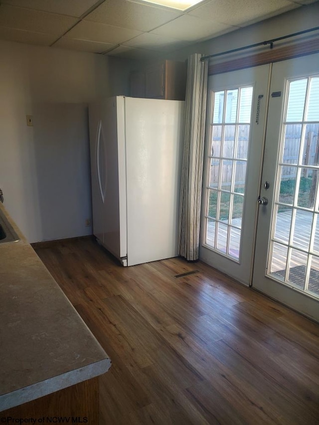 interior space featuring dark wood-type flooring, plenty of natural light, and a paneled ceiling