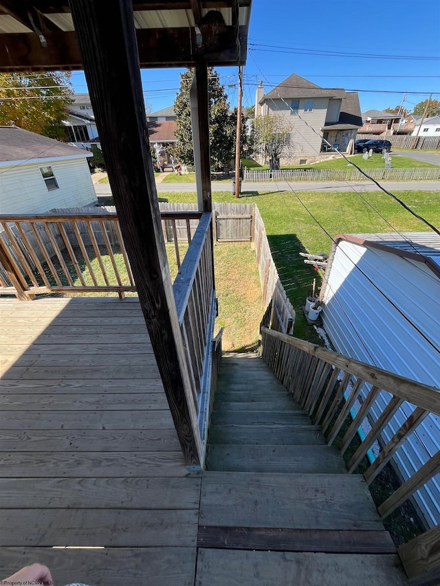 wooden deck featuring a lawn, a fenced backyard, and a residential view