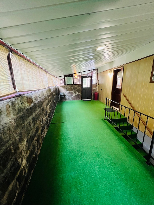 exterior space featuring vaulted ceiling and carpet floors