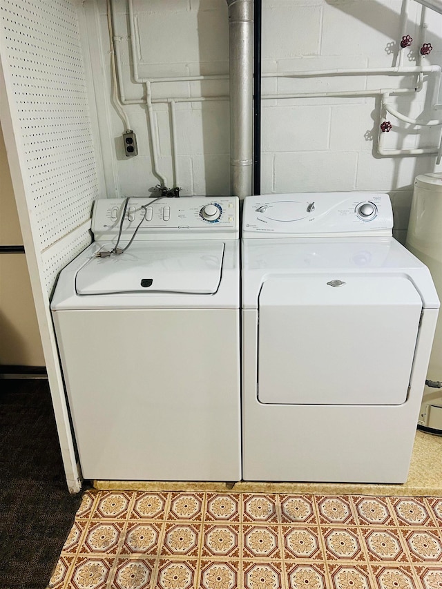 washroom with water heater and washing machine and clothes dryer