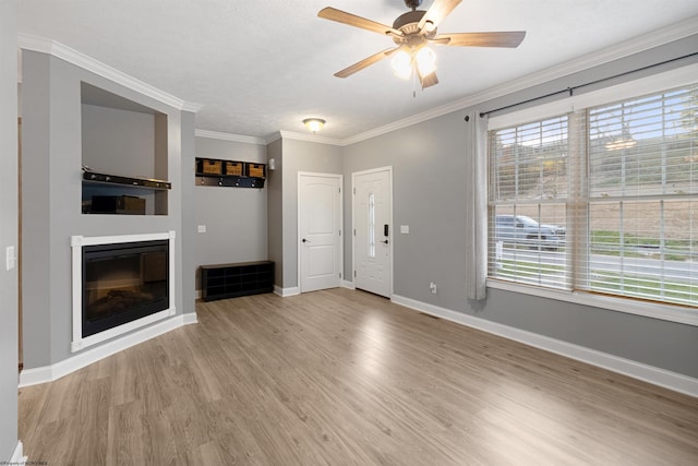 unfurnished living room with light hardwood / wood-style flooring, ornamental molding, a wealth of natural light, and ceiling fan