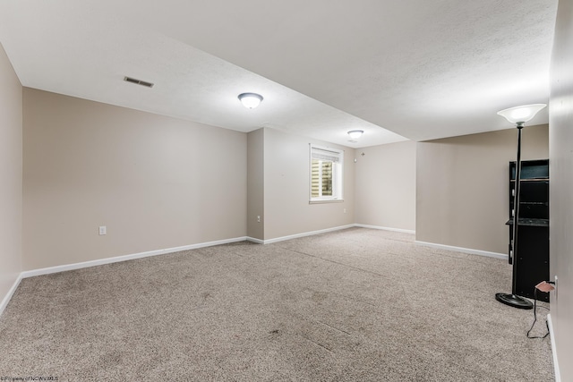 carpeted spare room with a textured ceiling