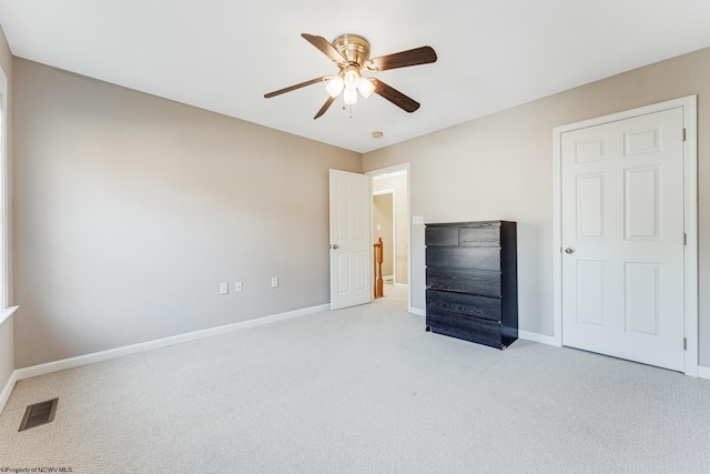 unfurnished bedroom with light colored carpet and ceiling fan