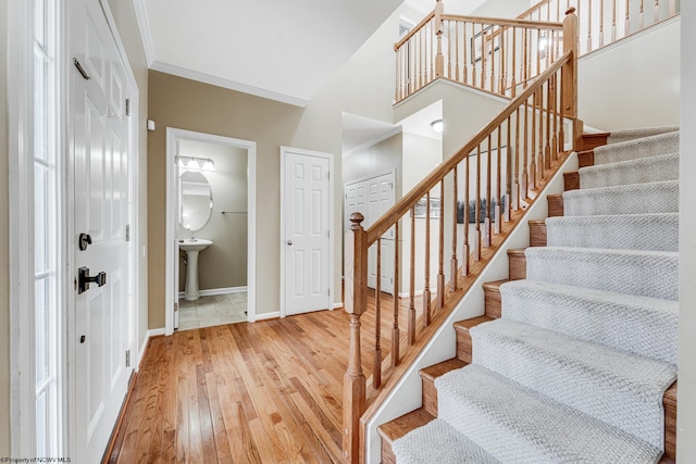 stairway featuring ornamental molding and hardwood / wood-style flooring