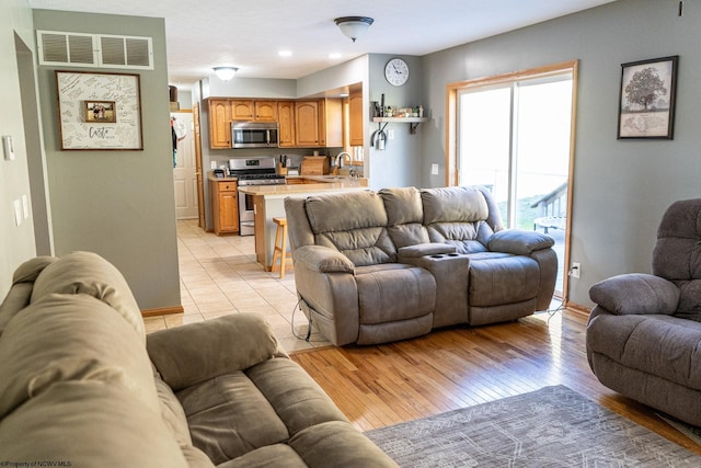 living room featuring light hardwood / wood-style flooring and sink