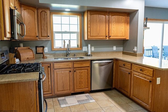 kitchen with stainless steel appliances, sink, light stone counters, and light tile patterned floors