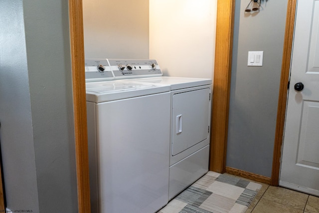 washroom with light tile patterned floors and washing machine and clothes dryer