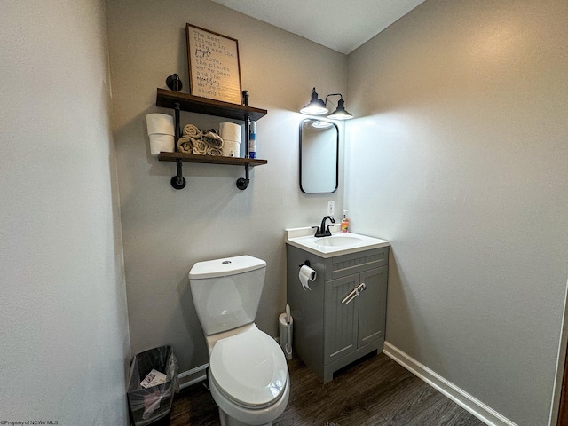 bathroom with vanity, hardwood / wood-style flooring, and toilet