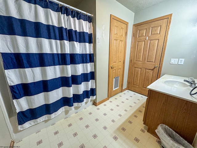 bathroom with vanity, a textured ceiling, and a shower with curtain