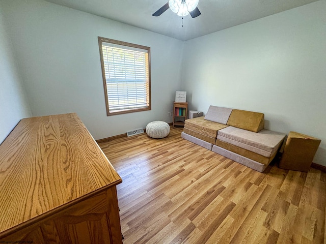 living area featuring light wood-type flooring and ceiling fan