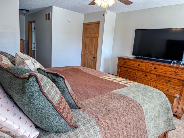 bedroom with ceiling fan, carpet, and a textured ceiling