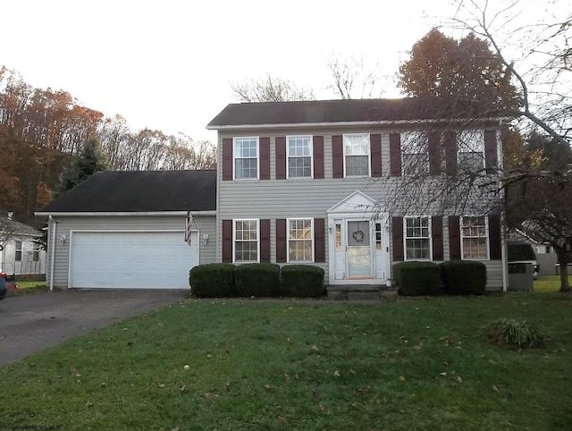 colonial inspired home with a front lawn and a garage