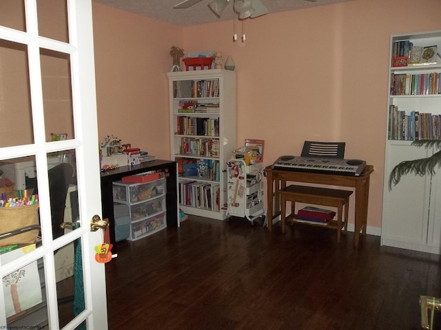 misc room featuring ceiling fan, a textured ceiling, and dark hardwood / wood-style flooring