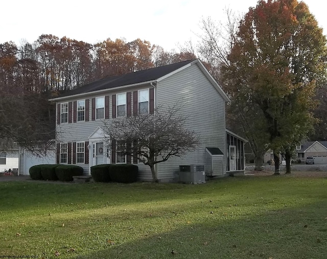 view of front facade with a front yard and cooling unit