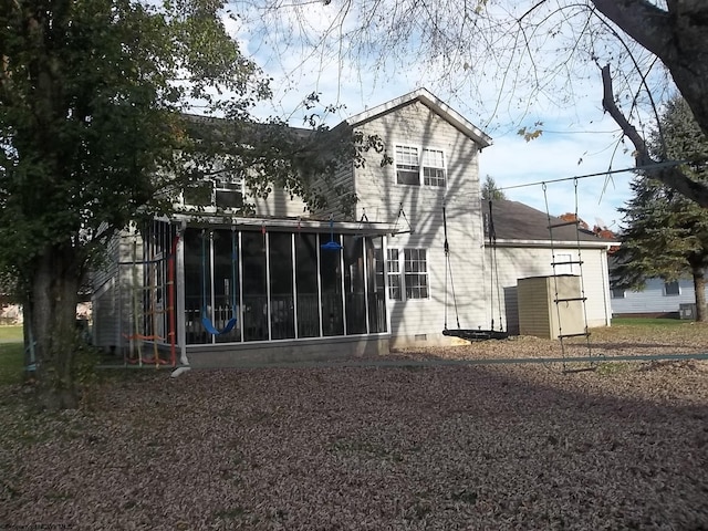 back of property with a shed and a sunroom