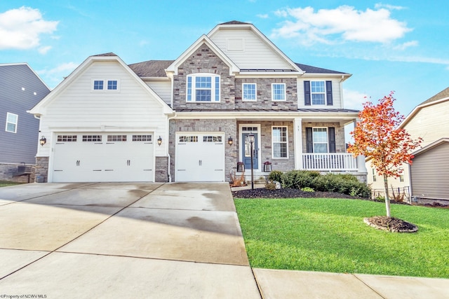 craftsman inspired home with a front yard, a garage, and a porch