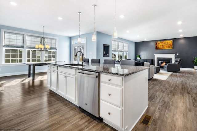 kitchen with white cabinetry, sink, stainless steel dishwasher, and a center island with sink