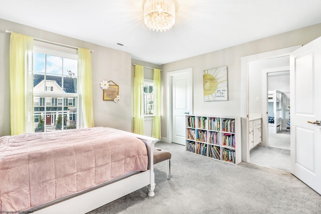 carpeted bedroom with an inviting chandelier