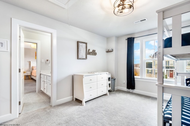 bedroom with light carpet and ensuite bathroom