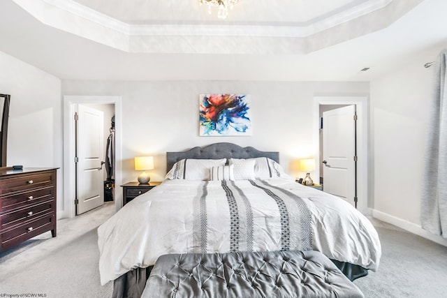 bedroom with crown molding, light carpet, and a tray ceiling